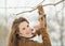 Smiling young woman hanging bird feeder on tree