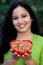 Smiling young woman hodling bowl of almonds