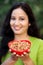 Smiling young woman hodling bowl of almonds