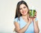 Smiling young woman holding blender with green smoothy ingredients.