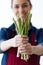 Smiling young woman holding a bunch of green asparagus over white background.