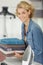 smiling young woman holding pile ironed towels