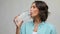 Smiling young woman holding water in glass bottle