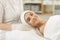 Smiling young woman looking at camera after procedure of facial massage