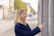 Smiling young woman pointing to a bus time table