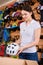 smiling young woman putting bicycle helmet in cardboard box while working