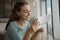 Smiling young woman reading paper correspondence letter.