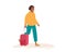 Smiling young woman with red suitcase walking down street. Tourism and travel concept. African American girl wearing