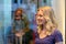 Smiling young woman reflected in a store window