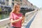 Smiling young woman scrolling messages on smartphone app to chat in Milan, Italy