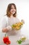 Smiling young woman serving fresh salad on plate Happy smiling cute woman cooking fresh healthy vegan salad at home with