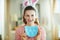 Smiling young woman showing blue chicken shaped plate for eggs