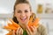 Smiling young woman showing fresh carrots