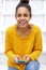 Smiling young woman sitting on stairs with cellphone