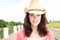 Smiling young woman standing in cowboy hat outside