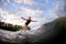 Smiling young woman stands on bright surf style wakeboard and rides down big water wave