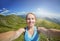 Smiling young woman takes a selfie on mountain peak