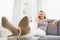 Smiling young woman talking cell phone in living room