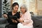 Smiling young woman teaching interested elderly mother how to use a tablet or shows some application. Elderly