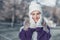 Smiling young woman in warm clothing on winter day outdoors. Happy girl wearing wool cap, scarf and sweater. Snow people concept