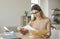 Smiling young woman who is excited by good news reads letter unfolded from paper envelope.