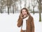 Smiling young woman in winter park talking cell phone