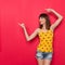 Smiling Young Woman In Yellow Dotted Shirt Pointing Away