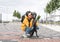 Smiling young woman in yellow hoodie hugging her fluffy shaggy gray dog, pet love and walking dog