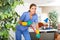 Smiling young workwoman of cleaning service mopping floors in office