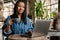 Smiling yuong african woman working on laptop