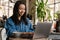 Smiling yuong african woman working on laptop