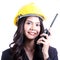 Smilling female construction worker talking with a walkie talkie
