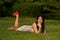 Smilling pretty Asian woman pose of lying on a lawn in the park