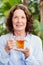 Smilng mature woman drinking herbal tea