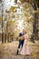 Smilng newlyweds hug under a fall of autumn leaves.