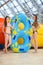 Smilng women in bikini standing near water slide in the aqua park