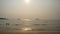 Smog obscures sun's rays. People relax on beach