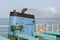 Smoke from ferry boat flue during sea with sunlight, sea water and clear sky in background, Thailand