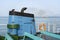 Smoke from ferry boat flue during sea with sunlight, sea water and clear sky in background, Thailand