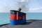 Smoke from ferry boat flue during sea with sunlight, sea water and clear sky in background, Thailand