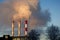 Smoke from industrial chimney against a blue sky.