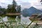 Smoke partially obscures trees on small islands on west coast of BC in summer with very calm sea and reflection