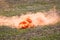 Smoke pellet with clouds of orange smoke on the battlefield