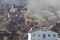 Smoke in a residential village among houses on fire. Houses against the background of fire bringing destruction and disaster.