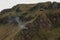 Smoke rises from a volcanic flue in the Batur Crater. Geological formation in active volcano with volcanic chimney.