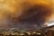Smoke from Sand brush fire covering Santa Clarita cityscape at sunset in California