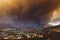Smoke from Sand brush fire covering Santa Clarita cityscape at sunset in California