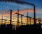 Smoke stacks at coal burning power plant, industrial silhouette.