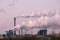 smoke stacks in a working factory emitting steam