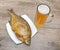 Smoked bream and a glass of beer on a wooden table